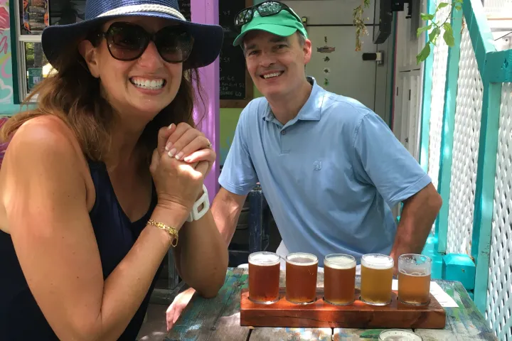 a man and a woman enjoying a flight of local craft beer