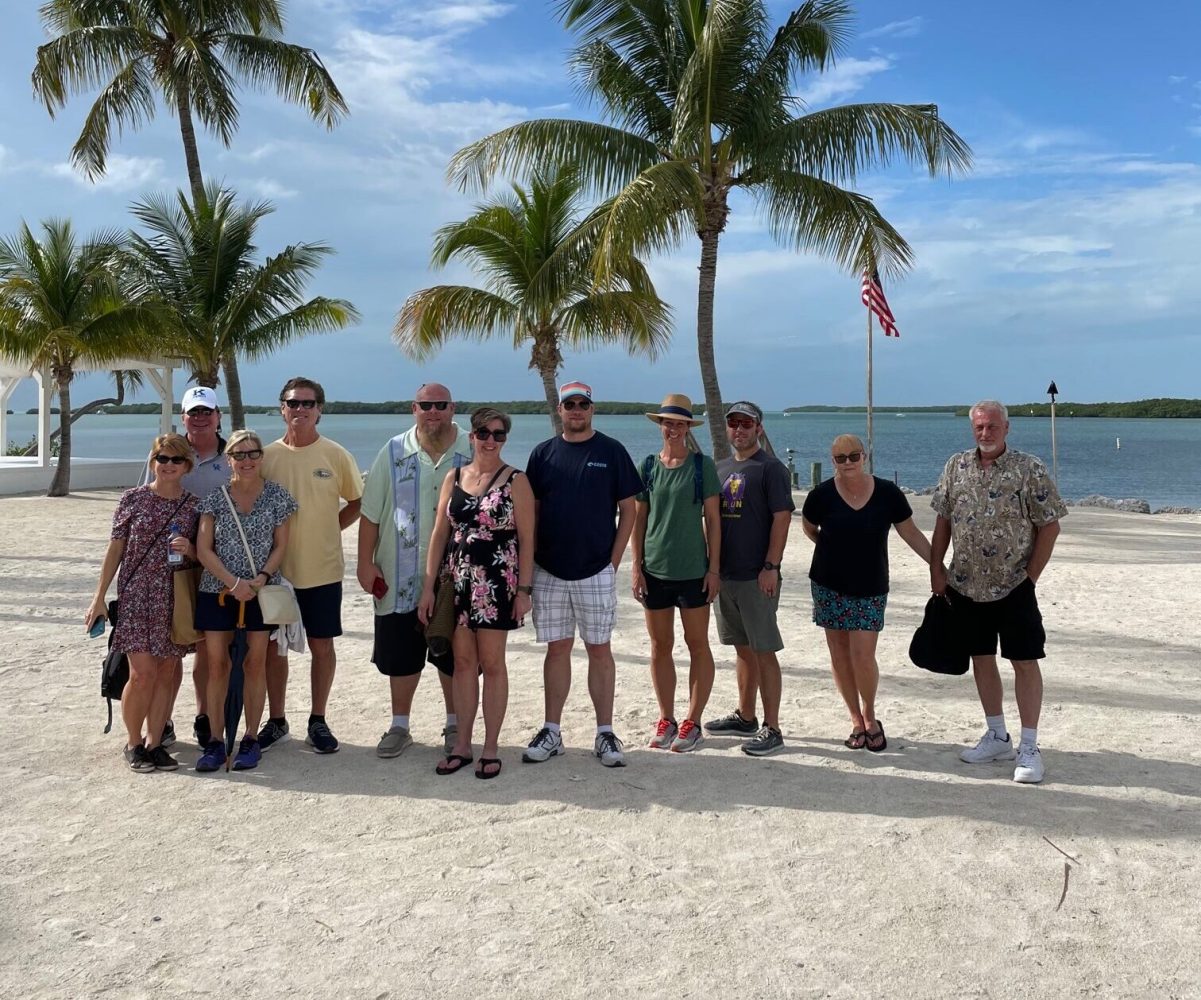 a group of people on a beach posing for the camera