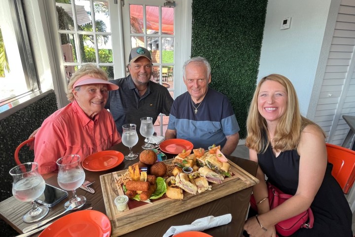 a group of people sitting at a table with food
