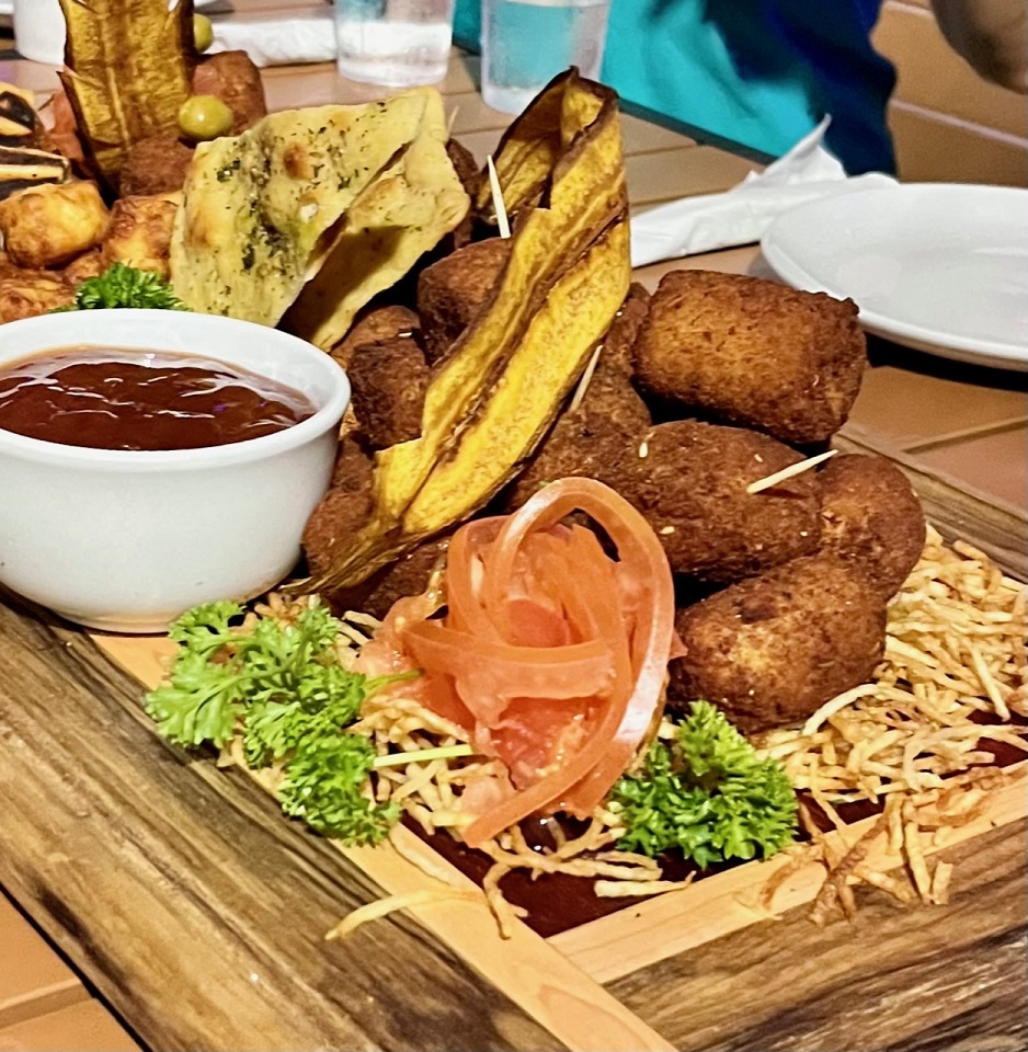 a bunch of cuban food sitting on top of a wooden table