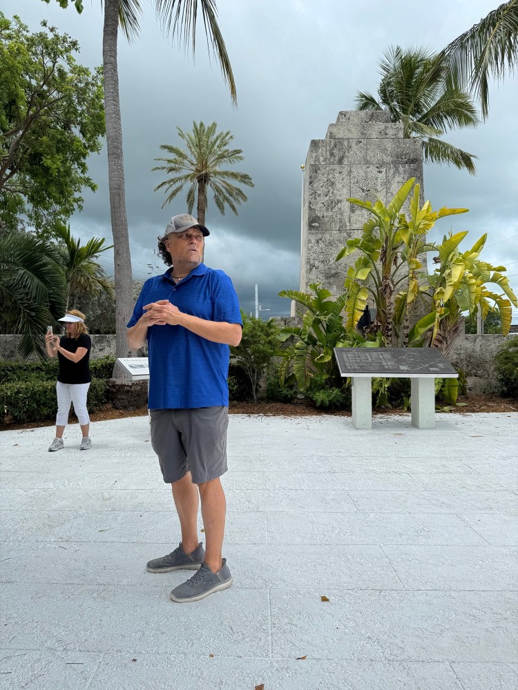 food tour guide craig in tropical setting with palm trees and stone structure.of hurrican monument