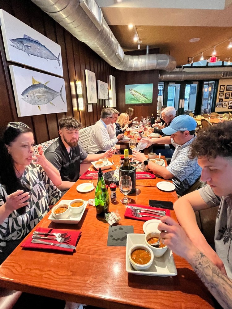 Group of people dining at the Green Turtle in Islamorada with fish artwork on walls.