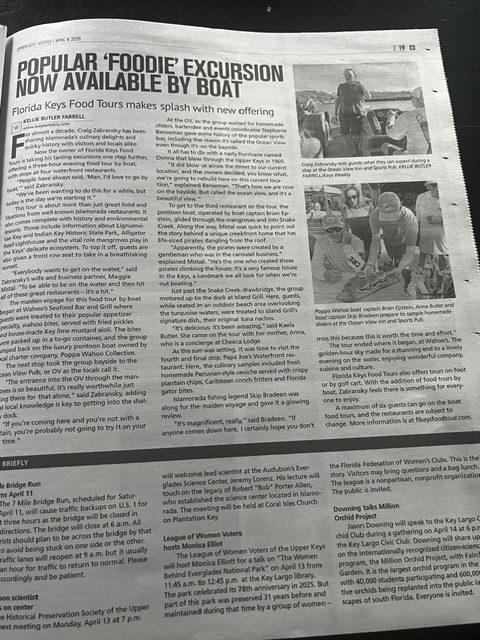 Newspaper with articles and photos about a food excursion by boat.