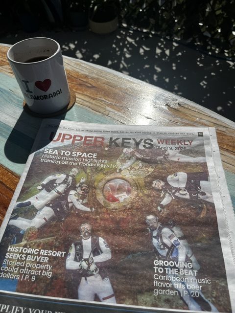 Newspaper on wooden table beside a coffee mug with heart design in Islmaorada Florida Keys